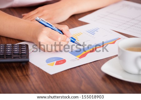 Close-up Of Female Hand Analyzing The Financial Data With Calculator