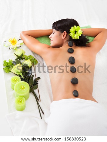 Beautiful Woman Relaxing At A Spa Receiving Hot Stone Massage