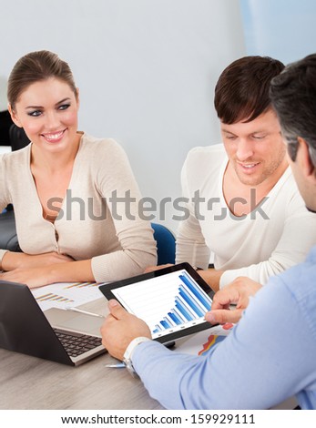 Business Executives At A Meeting Discussing Work On Digital Tablet