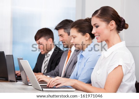 Happy Businesspeople In A Row Working Together At Office