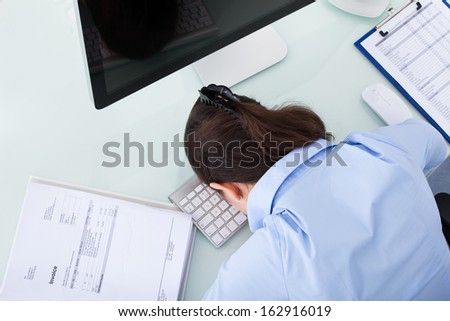 Portrait Of A Overworked Businesswoman Relaxing At Office Desk