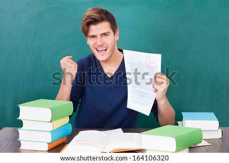 Portrait Of A Successful Student Holding Examination Paper