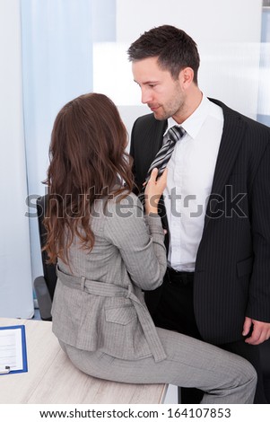 Naughty Businesswoman Holding Necktie Of Young Businessman