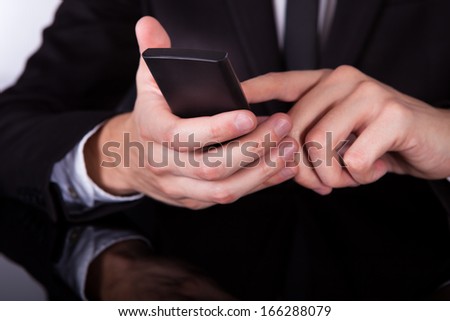 Close-up Of A Businessman\'s Hand Using Cellphone