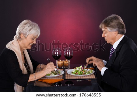 Happy Senior Couple Dining Together With Wine In A Restaurant