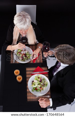 Happy Senior Couple Dining Together With Wine In A Restaurant