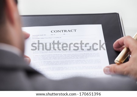 Close-up Of A Person Looking At Contract Form Holding Pen
