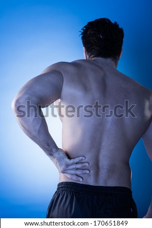 Rear View Of Young Man Suffering From Back Pain