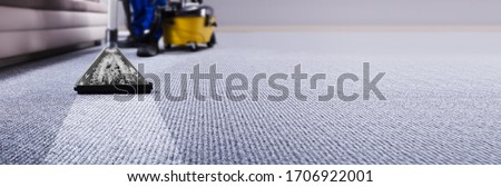 Professional Carpet Cleaning Service. Janitor Using Vacuum Cleaner