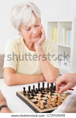 Senior Woman Playing Chess With Her Husband