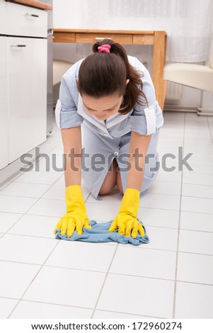 Portrait Of Young Maid Wearing Gloves Cleaning Floor