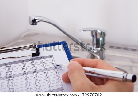 Hand Writing With Pen Water Consumption Level In Front Of Watertap