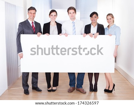 Group Of Happy Businesspeople Holding Blank Placard
