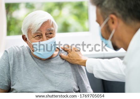 Doctor Talking To Elderly Patient At Home