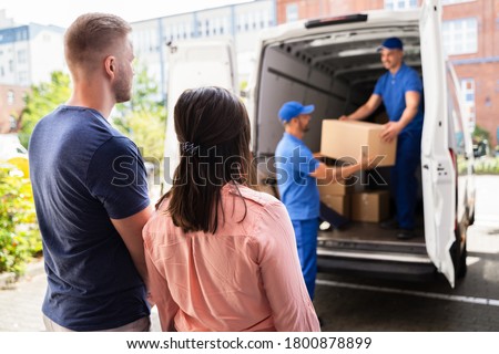Happy Family Couple Watching Movers Unload Boxes From Truck Stock foto © 