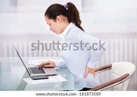 Young Businesswoman Having Back Ache Sitting In Front Of Laptop