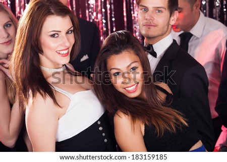 Portrait of cheerful young friends dancing in nightclub