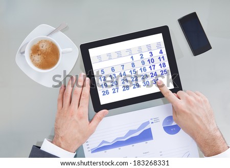Close-up Of Hand Pointing At Calendar Shown On Digital Tablet