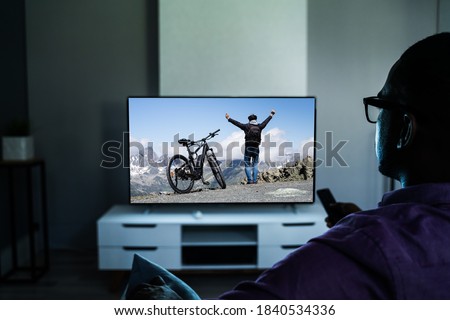 African Man Watching TV Movie Or Television In Glasses Foto stock © 