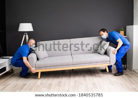 Professional Movers Moving Couch Furniture In Face Mask Stockfoto © 