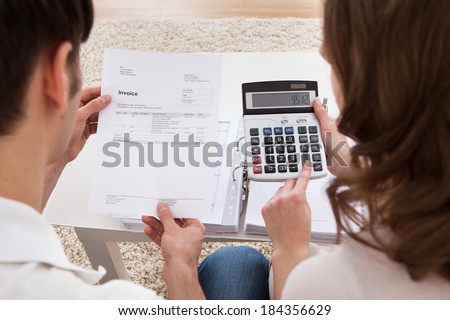 Portrait of young happy couple calculating budget