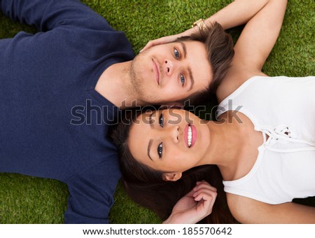 Directly above shot of young couple lying on grass in park