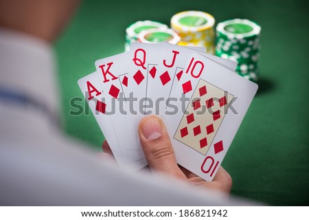 Cropped image of man playing winning hand of poker