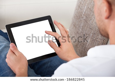 Man using his fingers to navigate on a tablet-pc  over the shoulder view of the blank touchscreen