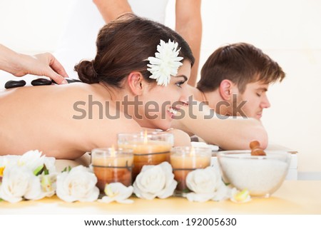 Young couple receiving Lastone therapy at beauty spa