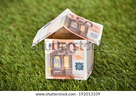 Closeup of house from euro money on grassy land