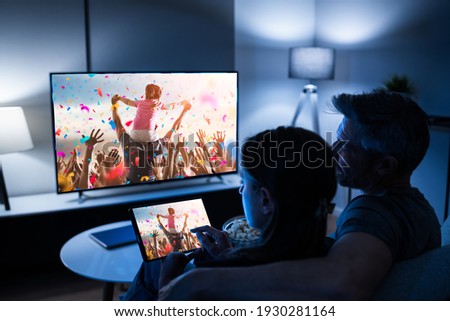 Family Watching TV Through Tablet Television And Movie Streaming