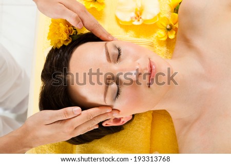 Directly above shot of beautiful woman receiving head massage in spa