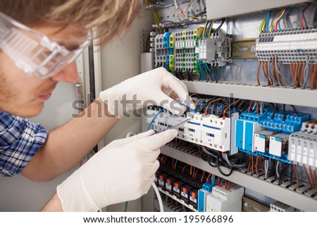 Cropped image of male electrical engineer repairing fusebox