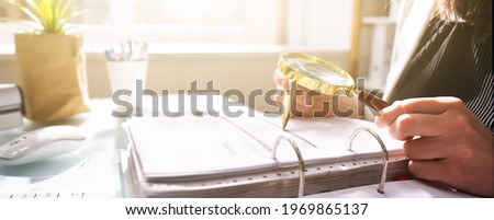 Fraud Investigation And Tax Audit. Investigator Or Auditor Using Magnifying Glass Stock foto © 