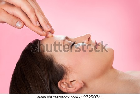 Side view of young woman receiving head massage in spa