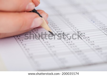 Cropped image of businesswoman writing on financial paper