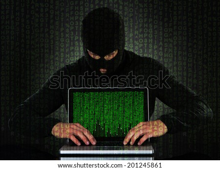 Hacker typing on laptop with binary code
