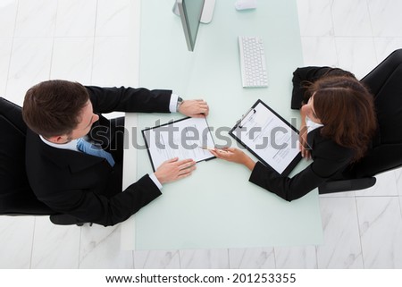 Directly above shot of young businesswoman interviewing male candidate in office