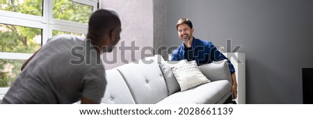 Couple Moving Furniture In Living Room. Carrying Sofa Photo stock © 