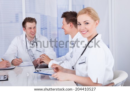 Portrait of happy young female doctor in conference meeting