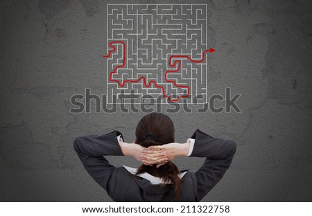 Rear view of businesswoman looking at solved maze drawn on wall
