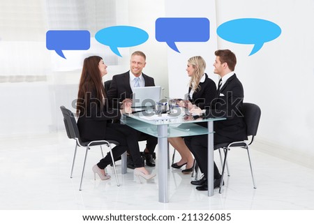 Business people with thought bubbles having discussion in board room
