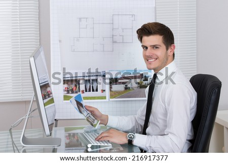 Side view of real estate agent working on computer in office