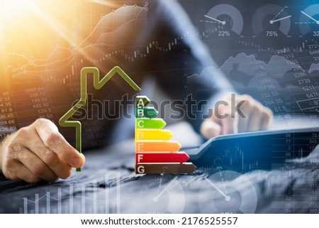 Close-up of a businessman using calculator holding outline of house model with energy efficiency rate Foto stock © 