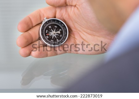 Business advisor holding compass. Over the shoulder view