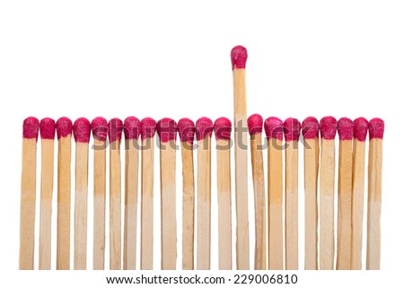 Row of match sticks with one coming up against white background