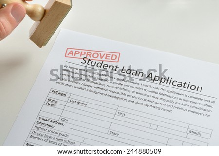 Close-up Of Person Hand With Rubber Stamp And Approved Student Loan Application