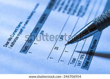 Close-up Of A Person Filling Invoice Paper With Pen