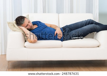 Portrait Of A Man Sleeping On Couch At Home