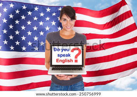 Young Woman Holding Laptop Asking Do You Speak English In Front Of Usa Flag
